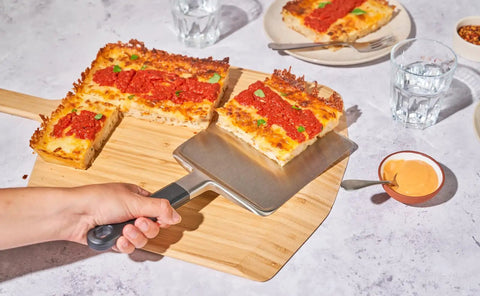 Heavy Duty 14 Inch Bamboo Pizza Peel And Wooden Spatula Paddle For Backyard Cookouts Smooth Launch Slide Design, lifting a slice.