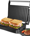Aigostar 1000w Panini Press Sandwich Maker Non Stick Plates with grilled sandwiches and steak on a countertop.