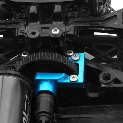 Close-up of TT02 Aluminum Open End Gearbox Cover installed on Tamiya RC car showing gear visibility and sleek blue finish.