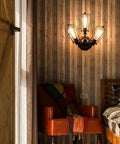 Vintage Industrial Ceiling Light With Metal Wire Cage Shade installed in cozy rustic bedroom setting.