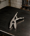 Get These Bad Boy Locking Pliers. Ten Inch Carbon Steel Heavy Duty Vise Grips on a workbench, perfect for tightening screws.