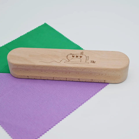 Wooden Clapper Tool For Pro Sewing And Quilting Nine Point Five Inch Hardwood Ironing Clapper on colored fabric squares