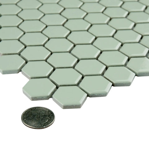 Metro Minty Hex Gloss Porcelain Tile For Floors And Walls, 1 Inch Hex, tiles next to a coin for size comparison, high sheen finish.