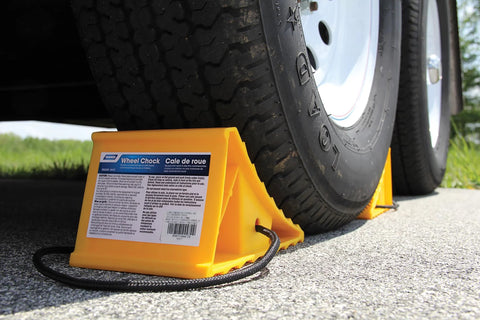 Camco wheel chock with rope, yellow plastic block for trailer tires up to 26 inches.