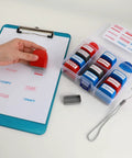 Top Notch Self Inking Stamp Set Boasts A Knockout 12 Pack Of Red And Blue Rubber Stamps on a clipboard with paperwork.