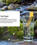 Full Range 0 to 14 pH Test Strips Litmus Paper in a glass with water and mossy rocks in background