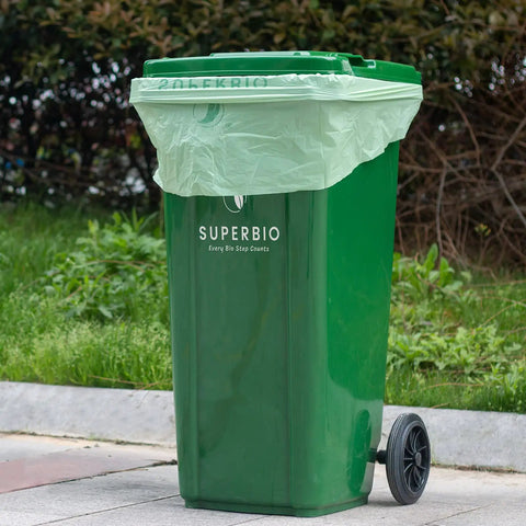 Green trash bin with 33 Gallon Compostable Yard Waste Bags For Lawn And Leaf Cleanup, showing bag fit and flat top design.