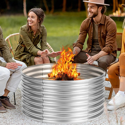 Friends enjoying a Huge 48 Inch Fire Pit Ring For Outdoor Wood Burning, Galvanized Steel Round Camp Fire Pit, in a backyard setting.