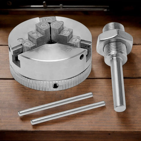 Three Jaw Chuck For Wood Lathe With Self Centering System Ideal For Woodworking CNC And Drills Expands Fixture Options Heavy Duty High Strength Chuck Delivers Stable Grip Smooth Operation And Precise Quick Change Capabilities., silver metal three-jaw self-centering chuck with key and adapter on wood surface