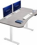 Upgrade Your Workspace With This Slick Dark Gray Standing Desk Measuring Sixty-Three By Thirty-Two Inches. Top view with dual monitors.
