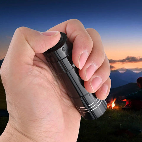 Hand holding one of the 5 Pack Dope Mini LED Flashlights Handheld Aluminum Torches With Lanyards And AAA Batteries Included in a twilight landscape