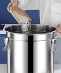 Heavy Duty 304 Stainless Steel Airtight Food Dispenser Big Boy 26 Gallon Grain Bin being filled with rice from a basket.