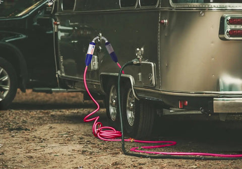 Heavy Duty Inline Water Filter Removes Chlorine And Strange Flavors With Five Layer Filtration connected to RV in campground setup.