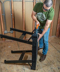 Person setting up the MODbox Folding Work Bench On The Go Quick Set Up Heavy Duty 1000 Pound Capacity Portable Work Table in a workshop.