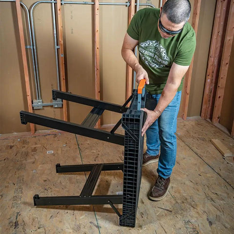 Person setting up the MODbox Folding Work Bench On The Go Quick Set Up Heavy Duty 1000 Pound Capacity Portable Work Table in a workshop.