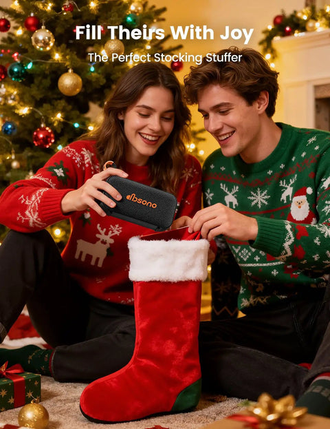 20W Bluetooth Speaker With Dope Stereo Sound 30 Hours Playtime IPX5 Water Resistant Portable Wireless Speaker With Deep Bass And Light Show Ideal Gift For Men Teens Adults Beach Vacation Essential Black being placed in a Christmas stocking by a couple in festive sweaters.