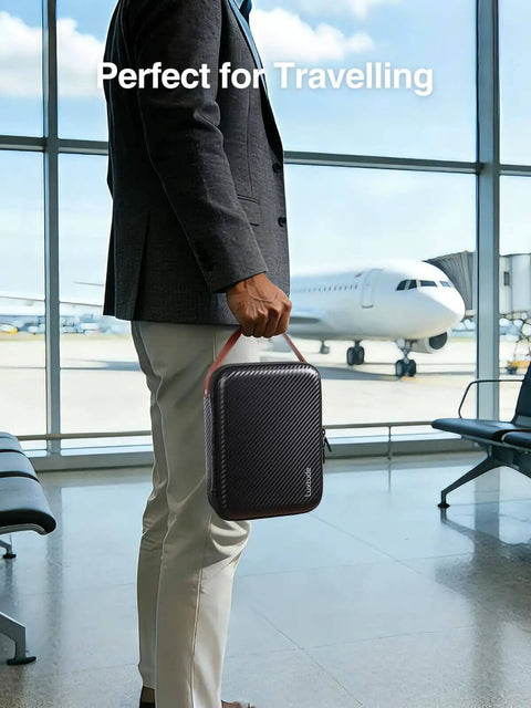 Totally Clutch Electronics Travel Organizer Case With Leather Handle For Chargers Cables And Tech Gear Keeps Your Setup Tight Perfect For Backpack Storage And Weekday Work Trips held in airport, black hard shell bag with leather handle.