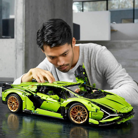 Person assembling Lamborghini Sian FKP 37 1:8 Scale Tech Model Car Kit For Grownups With 3,696 Pieces, Realistic V12 Engine.