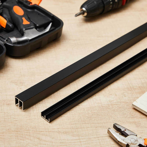Black Aluminum Sliding Door Track Set For Four Foot Installations No Fuss DIY Friendly For One Quarter Inch Panels Closet Glass Doors Cabinets And Windows Durable Aluminum Alloy Metal Sliding Track Easy To Cut And Install on a workbench with tools.