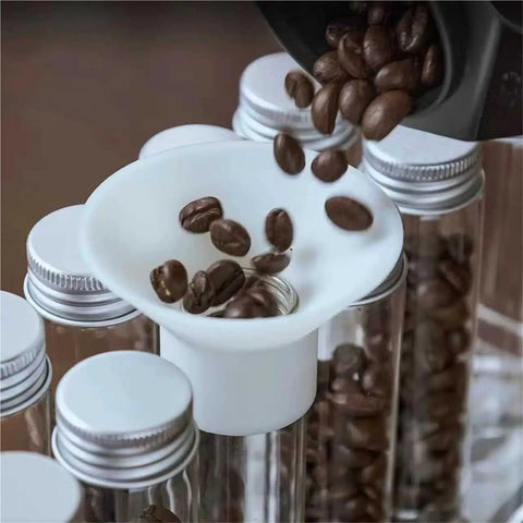 Single Dose Coffee Bean Storage Jars 14 Piece Glass Canisters With One Way Valve And Sturdy Metal Dispenser Stand Keeps Your Daily Roast Locked Up Tight And Ready To Grind Anytime, pouring coffee into glass jars.