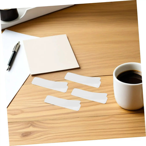 100 Pack Double Sided Hook And Loop Strips With White Pet Film Backing 2.5x10cm on a wooden desk with coffee cup.