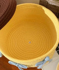 Inside view of Legit Handwoven Cotton Storage Basket With Snug Dustproof Lid in yellow, perfect for organizing bedroom clothes.