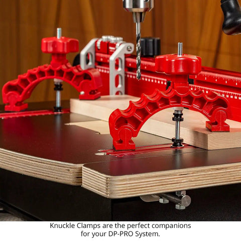 Close-up of Dead Nuts Straight 36 By 36 Inch Drill Press Table Master System with red knuckle clamps holding wood.