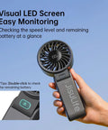Person holding 3 In 1 Handheld Fan With 5000mAh Battery, 12 Blade Brushless Motor Power, LED display showing 100% battery, black color.