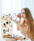360 Smooth Spin 3 Tier Makeup Organizer For Bathroom Counter Or Vanity Styling with glass bottles and a woman applying makeup.