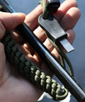 Hand holding Survival Fire Starter Kit With Drilled Ferrocerium Rod Half Inch By Six Inch Striker Pro Striker Paracord Lanyard