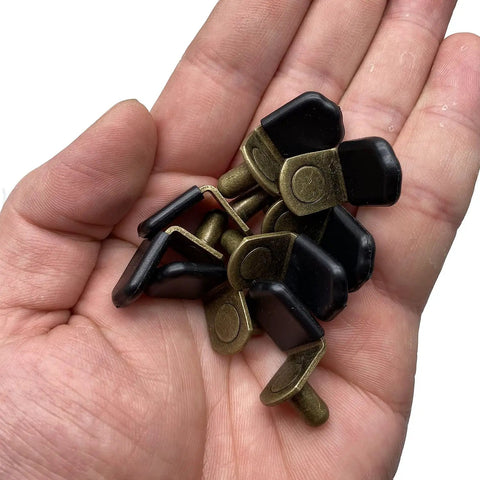 Glass Shelf Pegs In Bronze Tone Antique Bronze Finish For Cabinets Closets And Bookcases Bracket Style Pegs With Rubber Sleeve Six Millimeter One Quarter Inch Size Includes Thirty Pack held in hand
