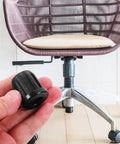 Hand holding a 0.98 inch Small Wheel Caster Socket Insert next to a computer chair, focus on plastic stem sleeve detail.