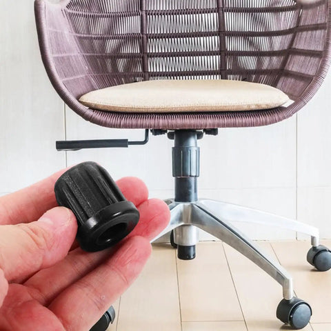 Hand holding a 0.98 inch Small Wheel Caster Socket Insert next to a computer chair, focus on plastic stem sleeve detail.