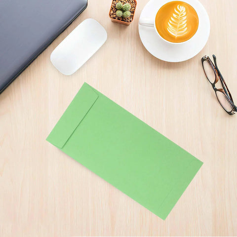 60 Pack Green Kraft Paper Coin Envelopes Self Seal With Double Adhesive on a desk with coffee and glasses