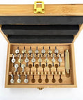 Open wooden box showing the Pro Grade 20 Calibers Watch Mainspring Winder Kit with adapters and copper tools for watch repairs.