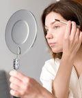 Woman using telescoping inspection mirror for close-up detail work
