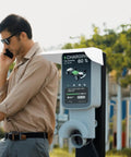 Heavy Duty EV Charging Station Rain Cover For Outdoor Wall Units Weatherproof Roof protecting charger while man talks on phone.