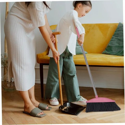 Heavy Duty Pink Broom With Extended Handle sweeps indoors, shown in use by a child for cleaning dust off the floor.