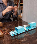 Super Compact Mini Wood Lathe Machine Featuring 96W Motor And Seven Adjustable Speeds Up To 9000Rpm For Precision Turning Punching Engraving Cutting Grinding Polishing Ideal Diy Projects With Lightweight Metal Body And Quick Change Chuck For Easy Setup in use for bead crafting.