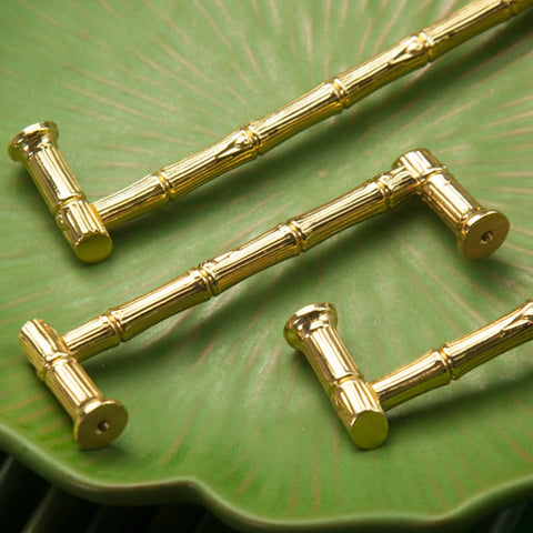 Gold Brass Bamboo Shape Cabinet Handles Set, Antique Brushed Copper Finish, displayed on a green surface