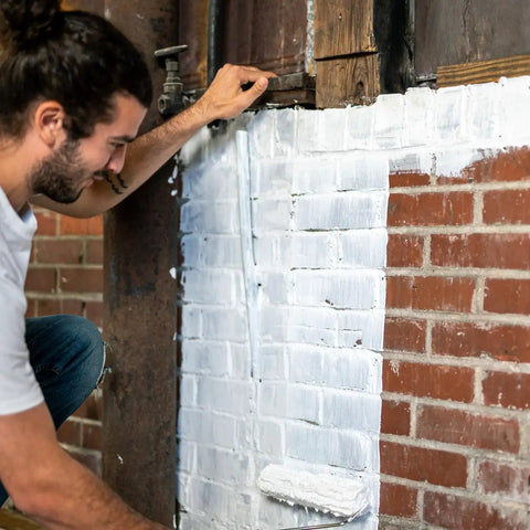 Man applying Block And Wall Liquid Rubber Waterproofer Pro Grade Multi Purpose Coating And Sealant For Concrete Walls And Foundations 1 Gallon White Made In USA Waterproof Basement Sealer on a brick wall