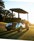 Golf cart on green field at sunset