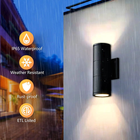 Modern Outdoor Wall Lights Up and Down Cylinder Sconce Matte Black Pack of 2 Waterproof Exterior Fixtures for Porch Patio Garage Front Door No Fuss Mount Easy Install Durable All Weather Lighting mounted on wall, with light shining up and down in rain.
