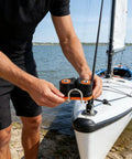 Person installing Quick Release Rope Clamp for Kayak Rigging and Marine Gear with Auto Locking Cam Cleat on white kayak.