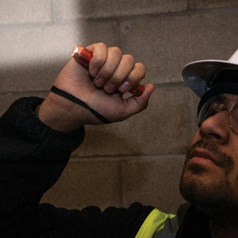 Rechargeable Pocket Flashlight With Dual-Direction Clip, 275 Lumen High Power held by a worker in low light conditions