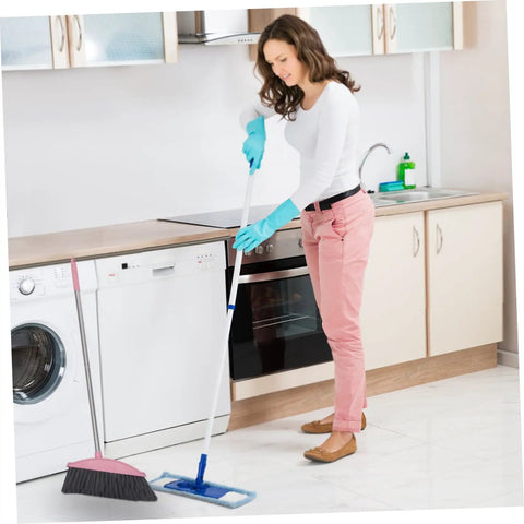 Legit Heavy Duty Pink Broom With Sturdy Steel Handle And Ultra Soft Bristles For Zero Sweat Indoor And Outdoor Floor Cleanup Compact Reusable Dust Brush That Really Cleans being used in a kitchen.
