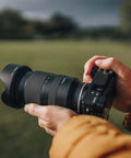 Person holding 17-70mm F2.8 Di III A VC RXD Lens For Sony E APS-C Mirrorless Cameras With Built-In Vibration Compensation And Fast Autofocus