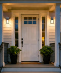 Black Exterior Wall Lanterns Set of 2 for Porch and Entryway lighting a white front door with plants.