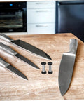 Top Tier Flat Head Knife Handle Screws Coupled With Heavy Gauge Stainless Steel Bolts Lock Down Blade Stability With Quick Thread Adjustments Tight Grip Badass Toolsmith Supply Pack, set of screws with kitchen knives on wooden surface.