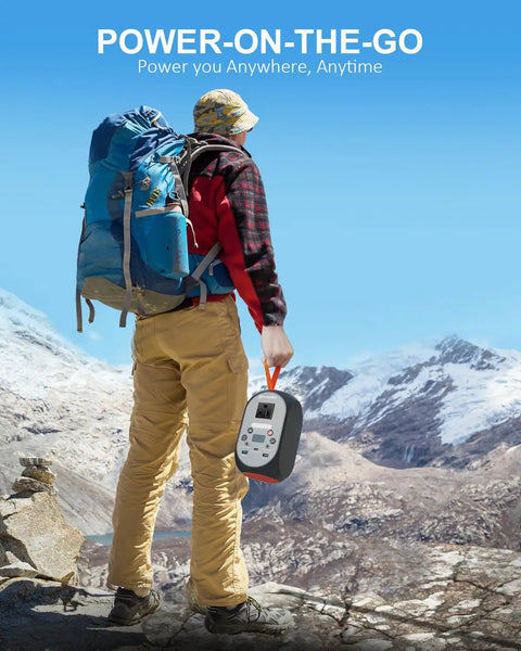 Hiker holding 99Wh Portable Power Station With LiFePO4 Battery, 120W Continuous Output, in mountain landscape.